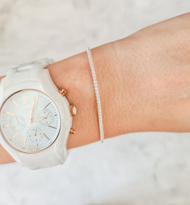 Sterling silver petite tennis bracelet seen on woman's wrist
