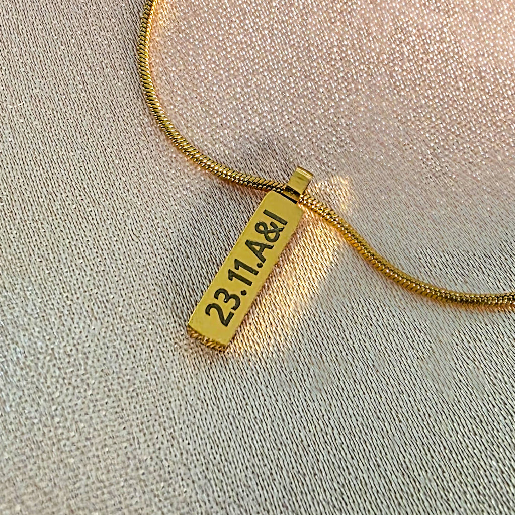 Gold engraved bar on a snake chain necklace.