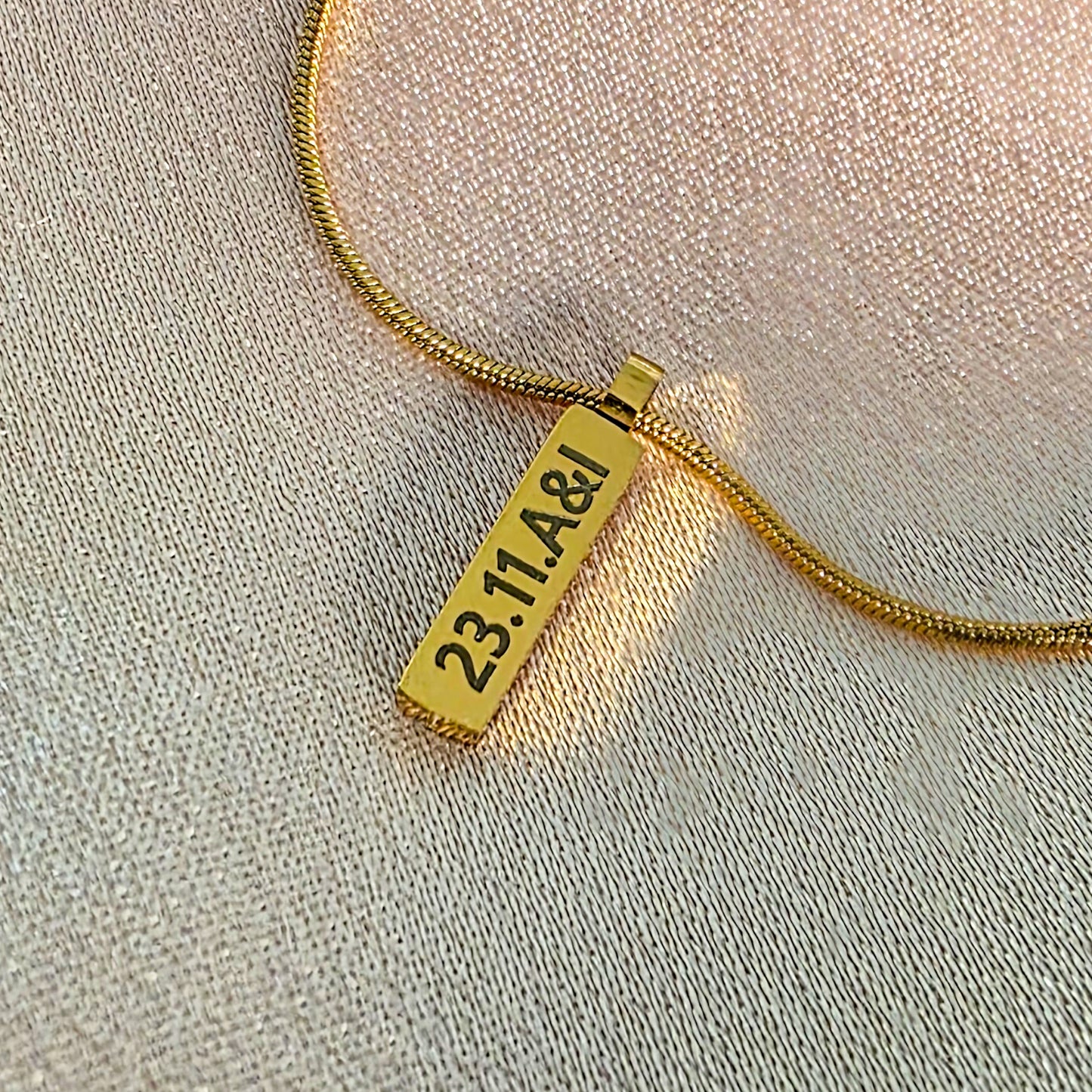 Gold engraved bar on a snake chain necklace.