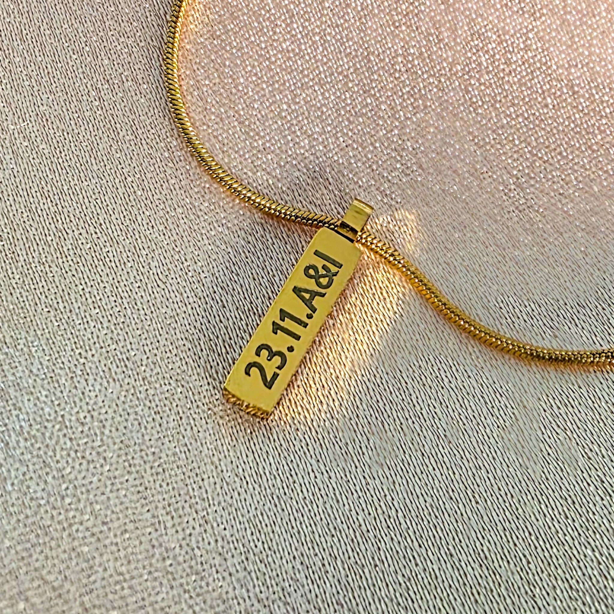 Gold engraved bar on a snake chain necklace.