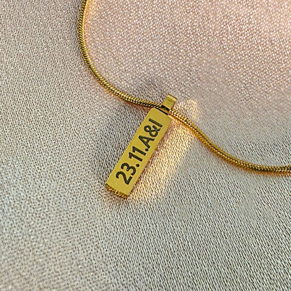 Gold engraved bar on a snake chain necklace.