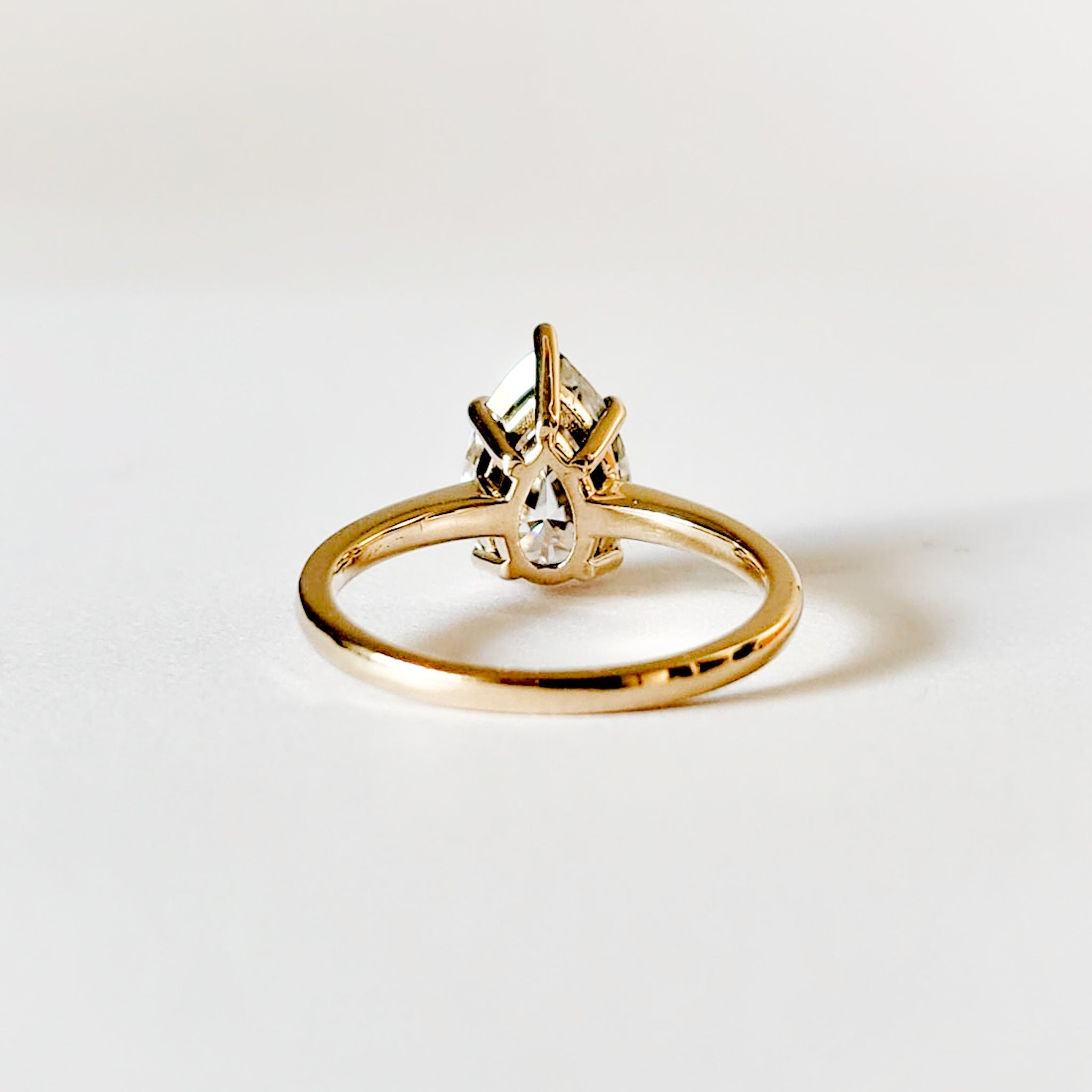 Ruth pear cut solitaire moissanite ring with five prongs set in yellow gold