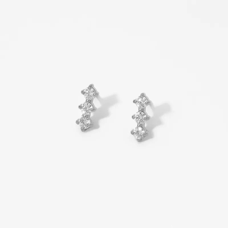 Pair of silver earrings with clear stones on a white background