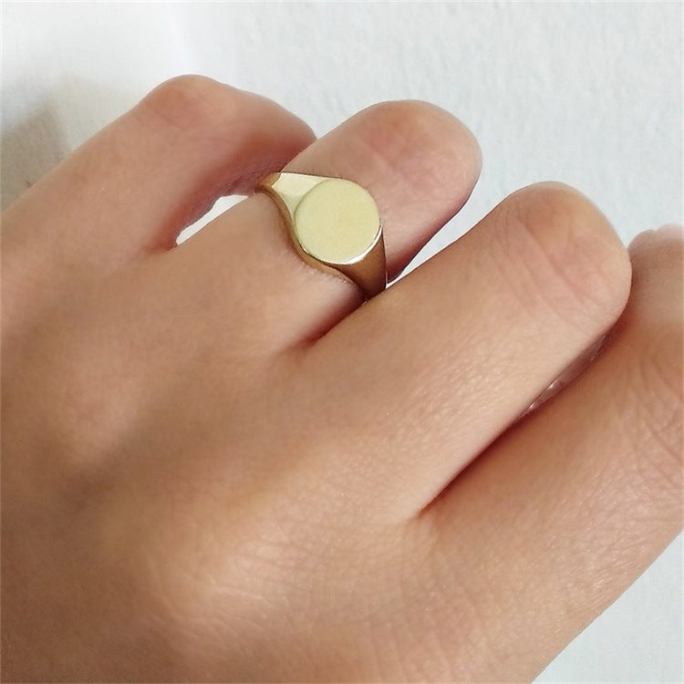 Gold ring on a finger against a white background