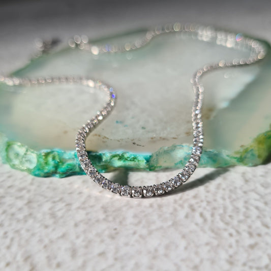 Sterling silver and cubic zirconia tennis choker necklace on green stone background
