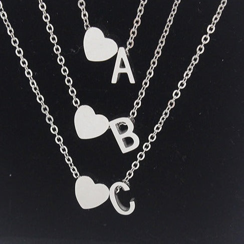 Stainless steel silver minimalist monogram and heart charm necklace.